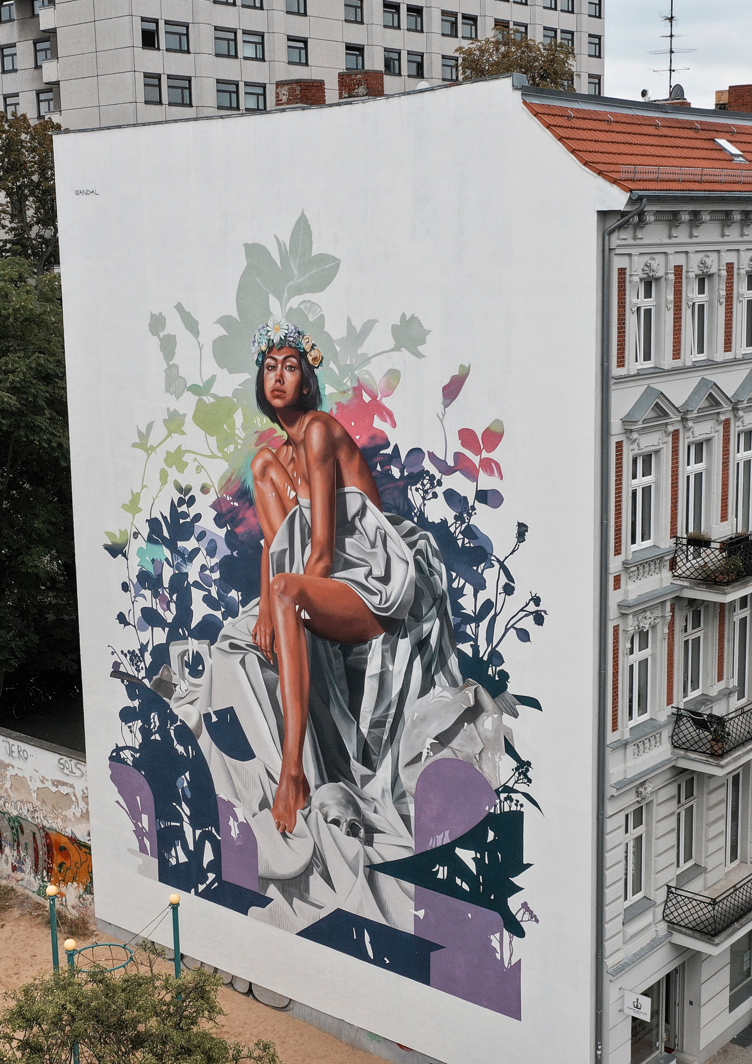Mother Nature mural by contemporary mural artist Wandal, featuring a seated woman surrounded by lush, stylized leaves – Moabit Berlin.